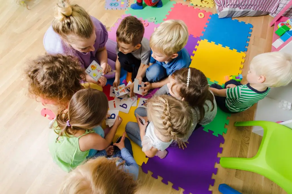 Toddlers at daycare in a circle with their teacher